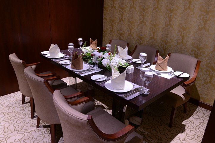 Al Aqeeq Madinah Hotel Medina Exterior foto The photo shows an elegantly arranged dining table set for a formal meal. The table is rectangular and made of dark wood. It is adorned with white plates, glassware, and neatly folded napkins placed on top of each plate. The napkins are in two colors